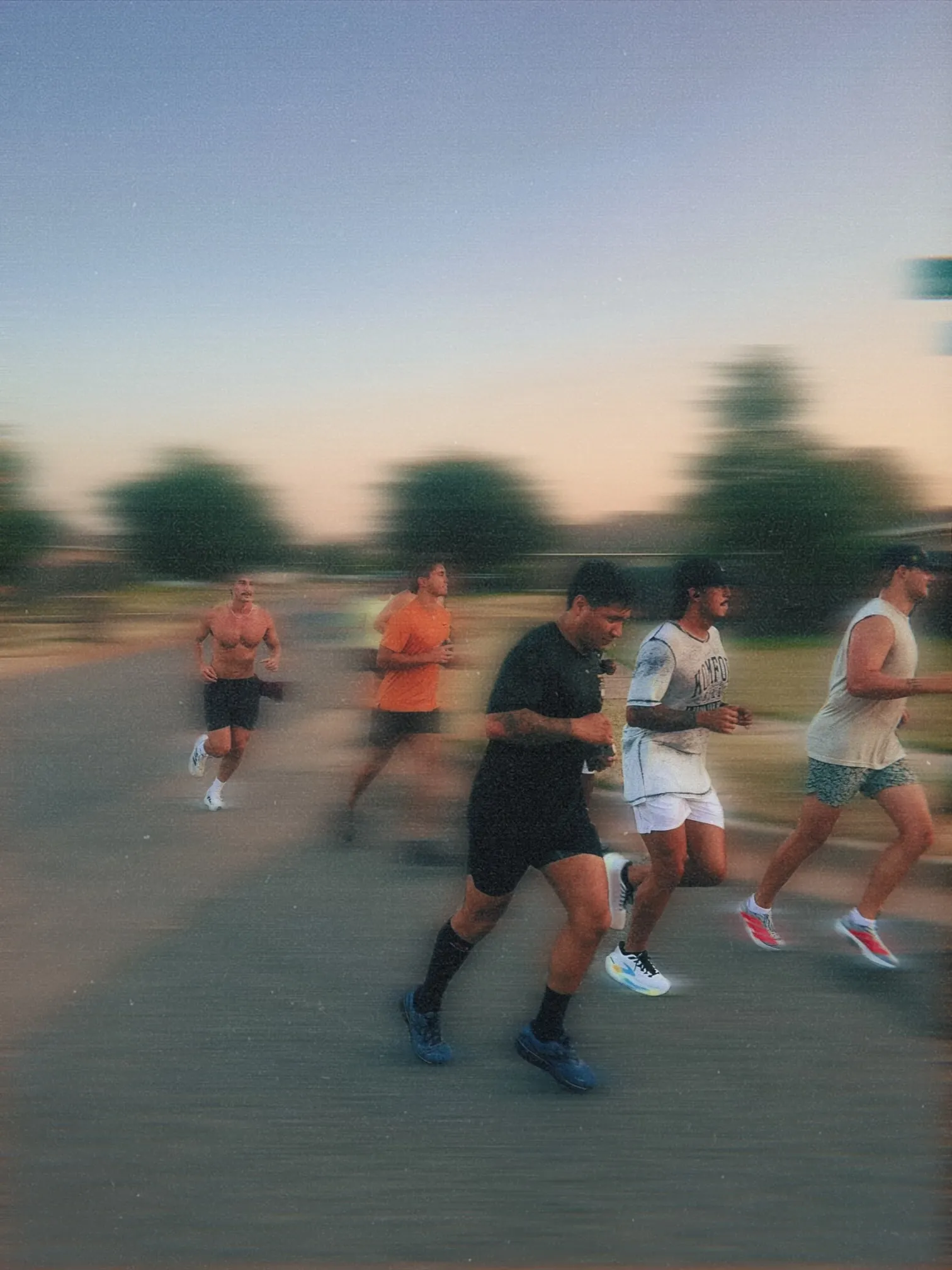 Men running together at golden hour with motion blur