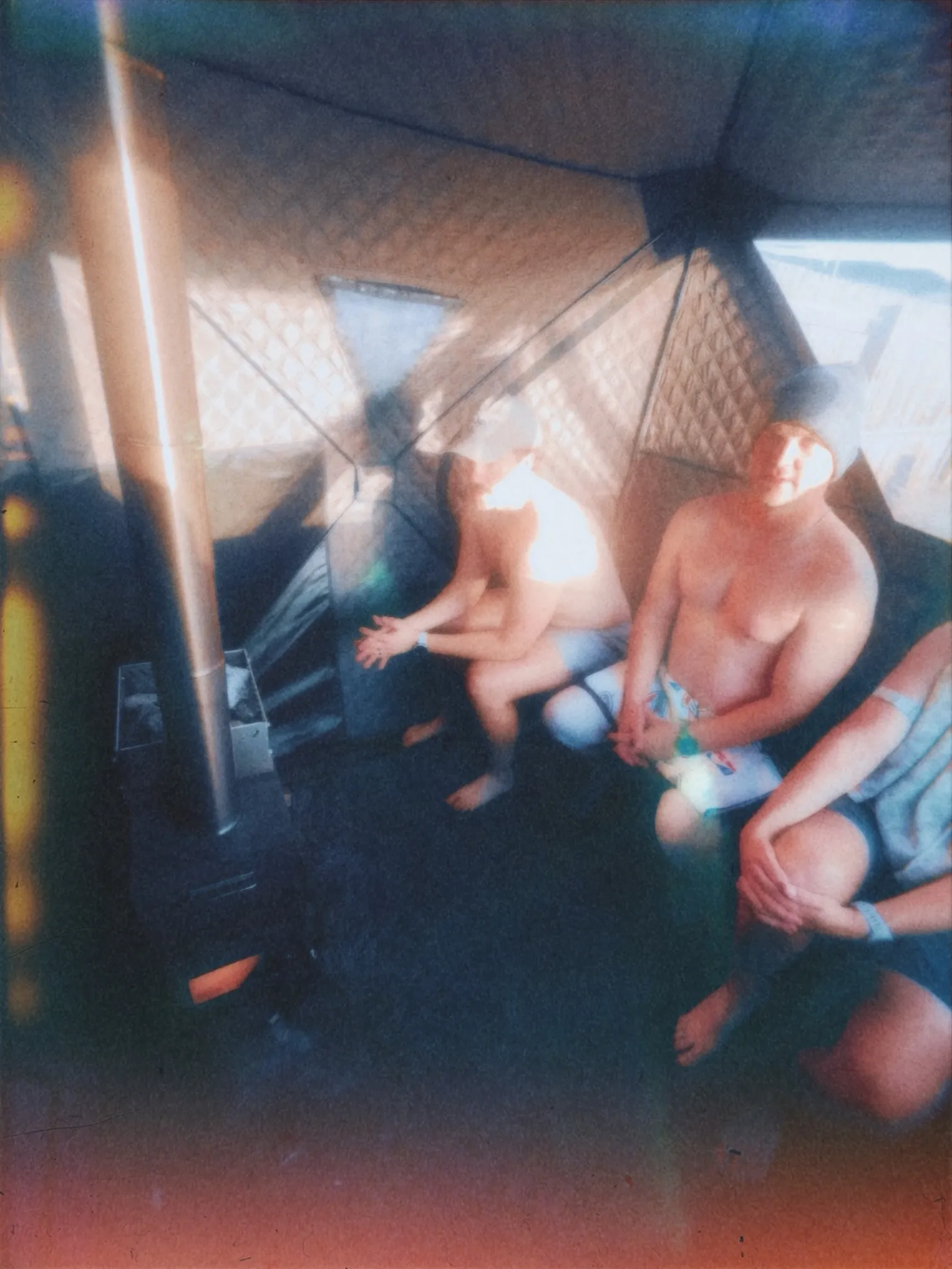 Men relaxing inside a wood-fired portable sauna