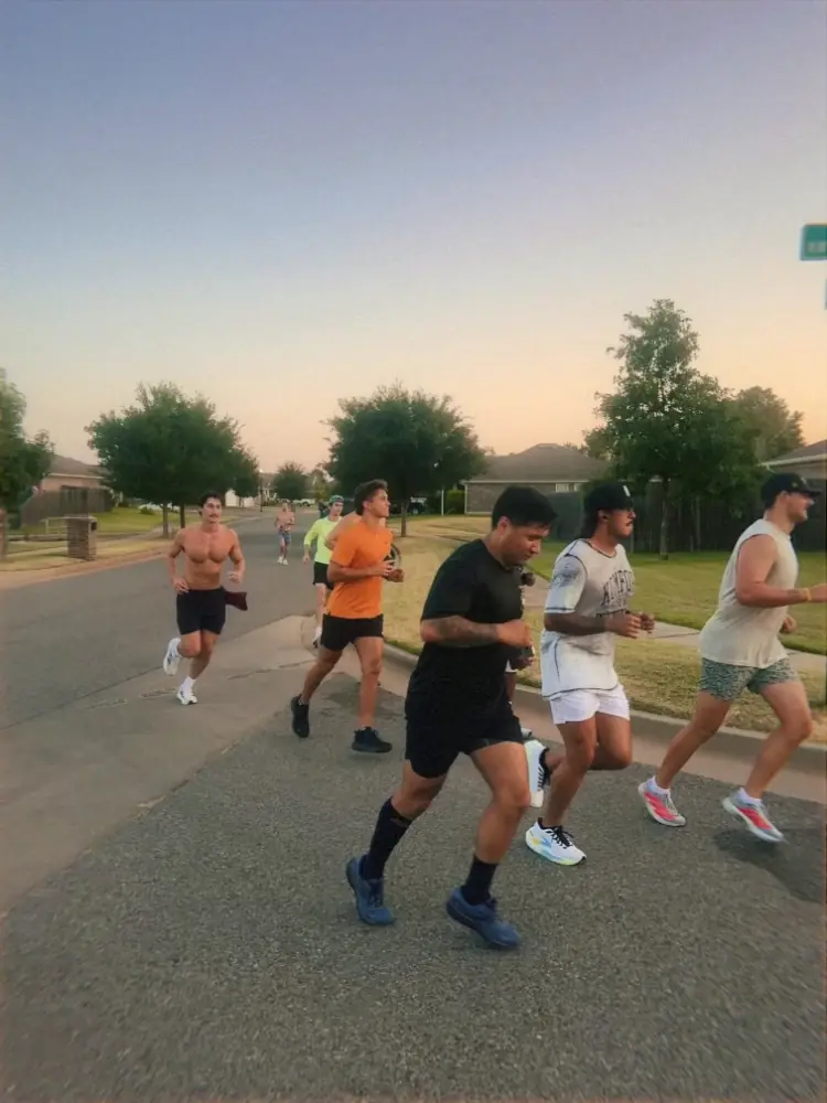Meantime runners going through the neighborhood